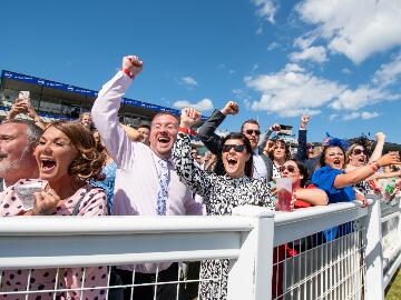 The crowd at the trackside at Newcastle Races going crazy cheering for their horses.