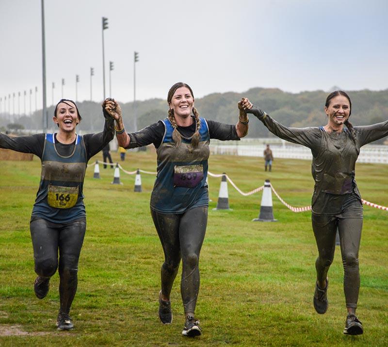 Three ladies cheering on while finishing the Stampede race at Newcastle Racecourse.