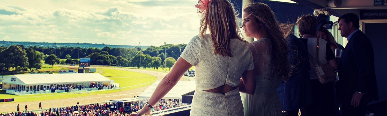 A group enjoy the view over Newcastle Racecourse from a hospitality area.