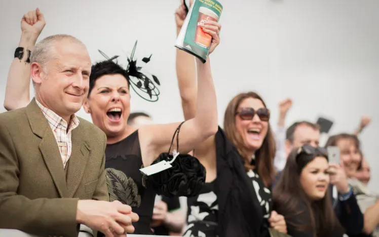 The crowd at Newcastle Racecourse cheer for a win