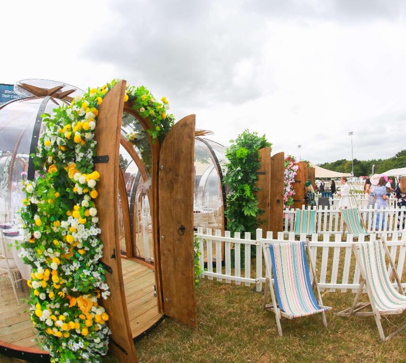 A number of glass hospitality pods complete with deck chairs and white picket fencing at Newcastle Racecourse.