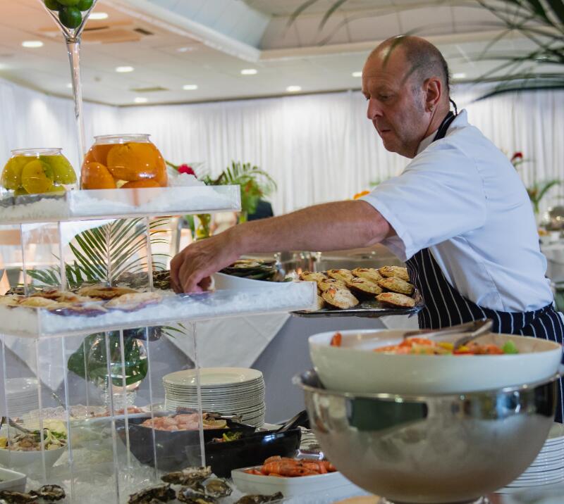 A chef setting up a buffet