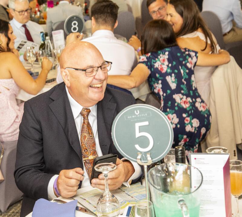 A hospitality guest laughing at his table at Newcastle Races